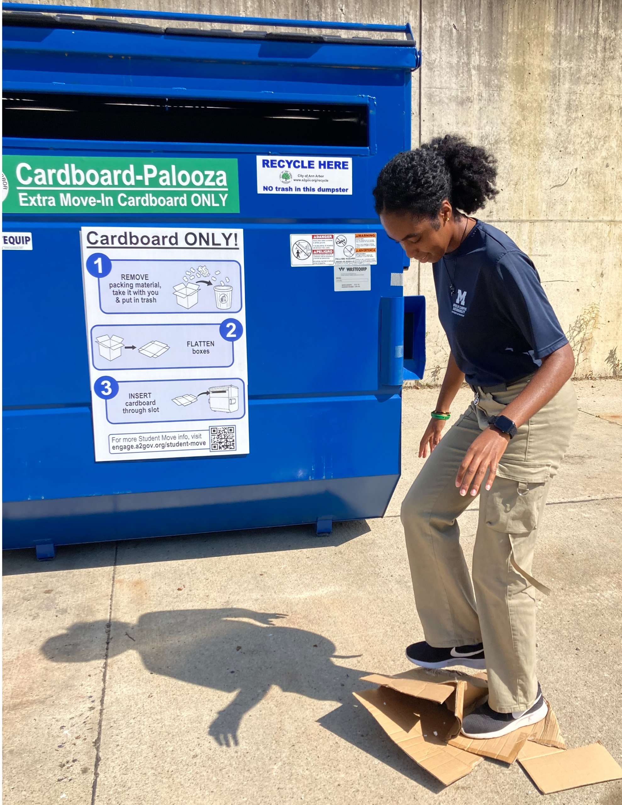 Woman crushing box so that it is flat. 