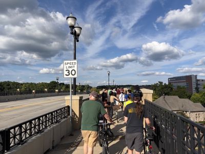 People gathered on sidewalk listening to a presentation on Division Street.